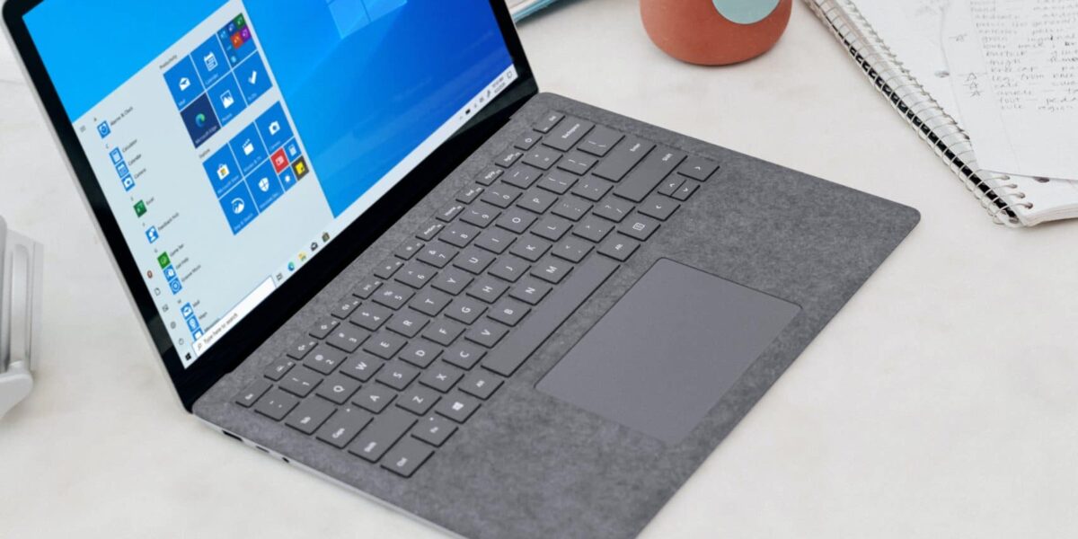 gray microsoft surface laptop computer on white table