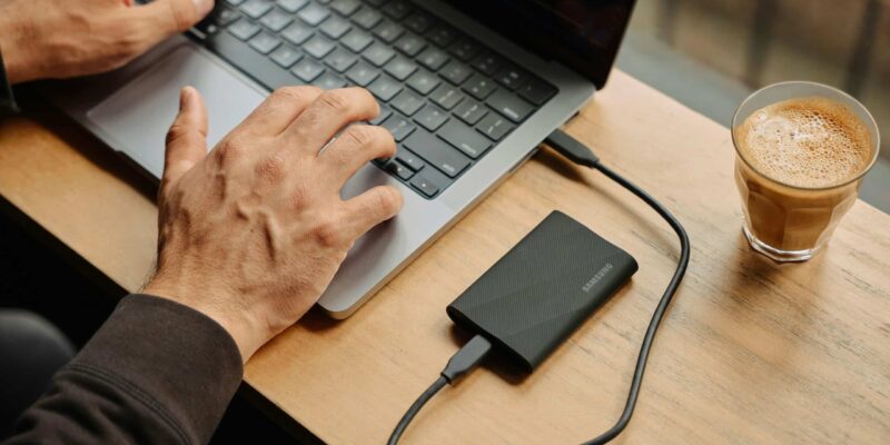 A man sitting at a table using a laptop computer