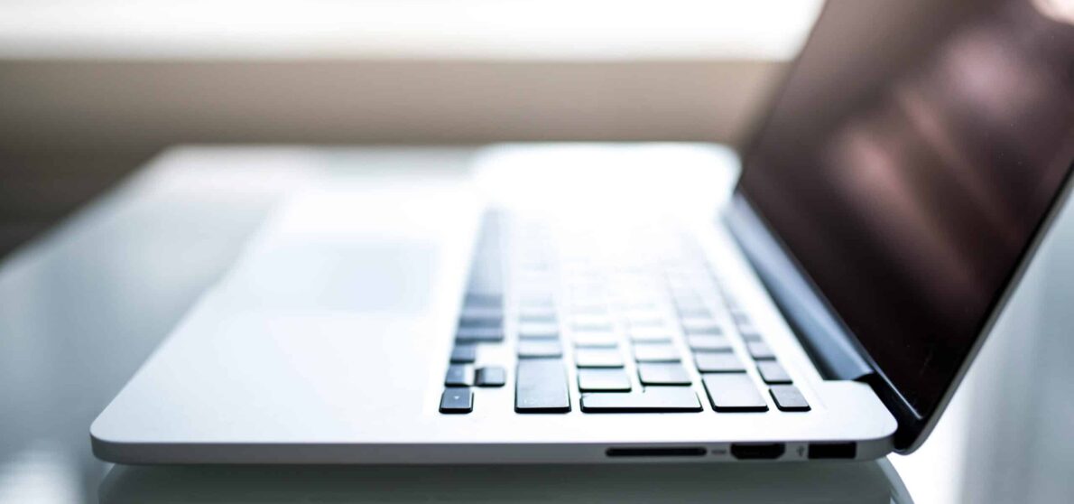 Free Elegant side view of a laptop on a glossy table with natural lighting indoors. Stock Photo