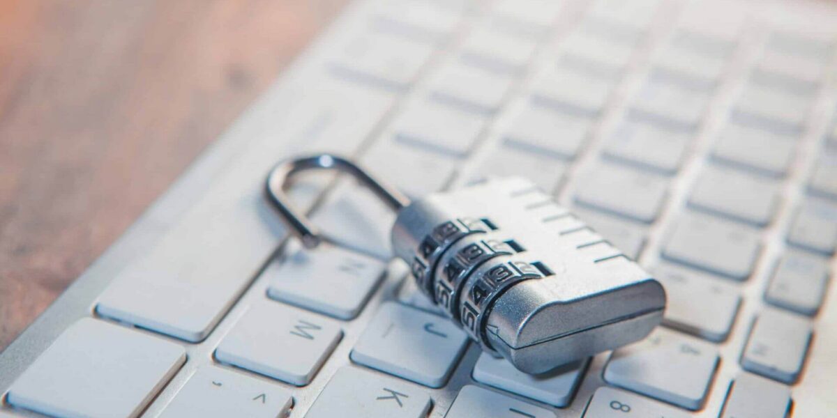 A combination lock rests on a computer keyboard.